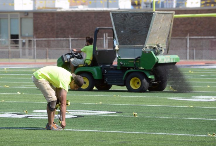 Mirror file photo by Patrick Waksmunski / Employees from TPK Inc., Allison Park, work on the turf at Hollidaysburg Area School District's Tiger Stadium in August. More than a quarter century ago, artificial turf first made its way onto a Blair County field following a vote from the then-Altoona Area School Board to install it at Mansion Park Stadium.